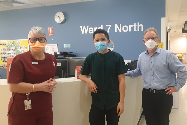 Suzanne Johnson, Dr Faza and A/Professor Peter Mount stand in front of the nurse station in Ward 7 North